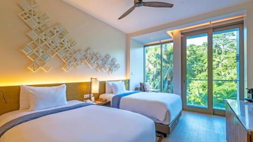 a hotel room with two beds and a window at Crimson Resort and Spa Boracay in Boracay