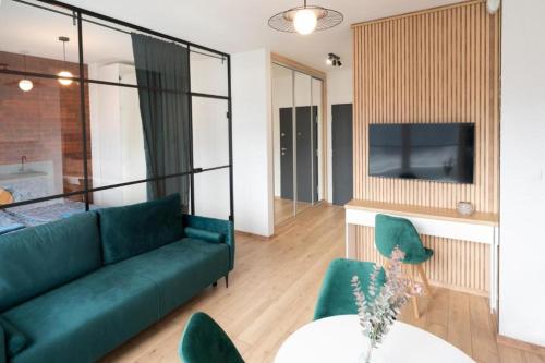 salon z zieloną kanapą i stołem w obiekcie Golden Apartments-Sok15 w mieście Katowice