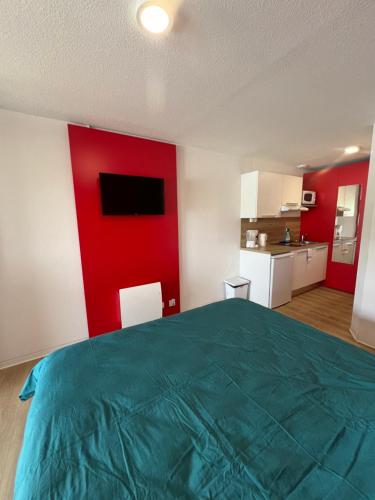 une chambre avec un grand lit et un mur rouge dans l'établissement JOIA Bassin d'Arcachon - NOTRO 208, à La Teste-de-Buch