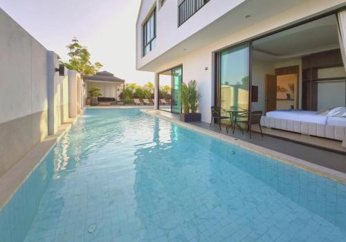 a swimming pool in a villa with a bed at Bangtao Luxury Pool Villa - Prymana in Phuket