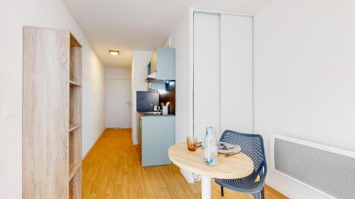 a small room with a table and chairs and a kitchen at Sweetly I-Art Gradignan - Bordeaux Sud in Gradignan