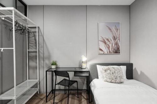 1 dormitorio con escritorio y 1 cama con silla en Modern Single Room - Next to Central Station - Near CBD&Townhall&Chinatown&Darling Harbour&UTS&USYD - Shared Bathroom, en Sídney