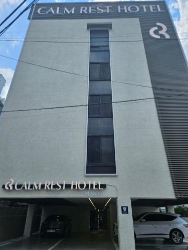 a building with a car parked in front of it at Calm Rest Hotel Masan in Changwon