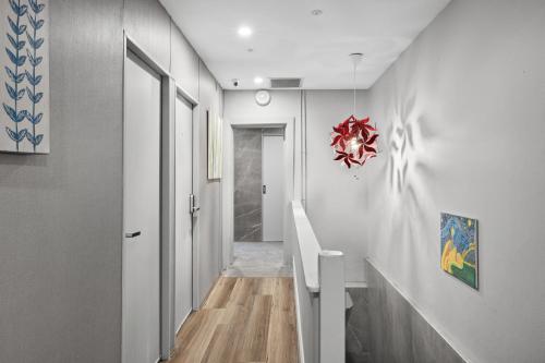 Un pasillo con paredes blancas y una lámpara de araña roja. en Modern Single Room - Next to Central Station - Near CBD&Townhall&Chinatown&Darling Harbour&UTS&USYD - Shared Bathroom, en Sídney
