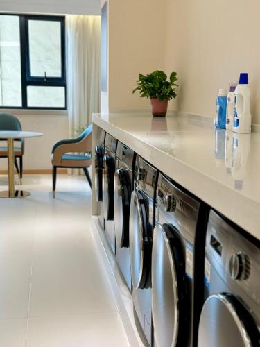 a row of washers and dryers in a room at Jin Jiang West Capital International Hotel the Bell and Drum Tower Muslim quarter & Metro Line 6 & indoor swimming pool & self-service free laundry room in Xi'an