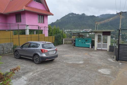 a car parked in front of a pink house at Avadale Kodaikanal - Stag Groups Not Allowed in Kodaikānāl