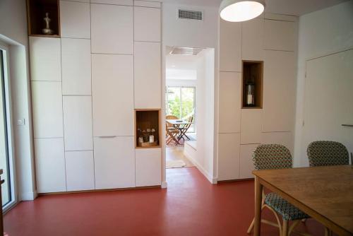 une chambre avec une table et des chaises ainsi qu'un couloir dans l'établissement La Cabane des Salants la Capte Presqu'île de Giens, à Hyères