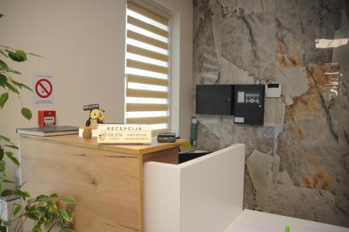 a reception desk in a room with a stone wall at Sobe Sova Kikinda in Kikinda