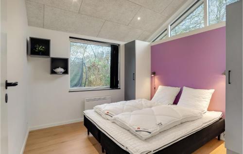 a bedroom with a large bed with a purple accent wall at Nice Home In Hurup Thy With Wifi in Sindrup