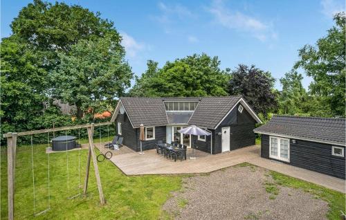a black house with a deck and a backyard at Awesome Home In Fårvang With Sauna in Fårvang