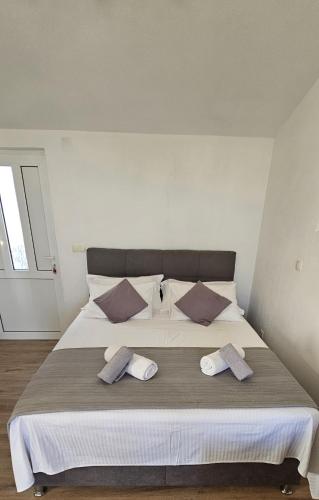 a bedroom with a large bed with two pillows at Apartment Grubelić in Tribunj