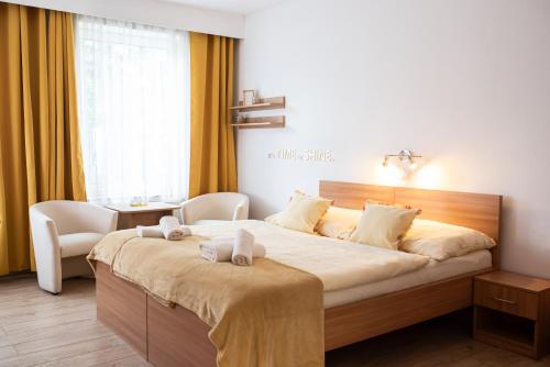 a bedroom with a large bed with two towels on it at Penzion Sankt Johann in Liptovský Ján