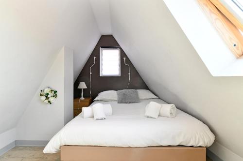 une chambre avec un lit blanc dans un grenier dans l'établissement Appartement Villa Joseph, à Kaysersberg