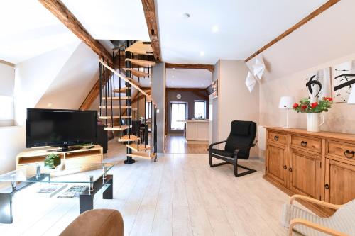 un salon avec une télévision et un escalier dans l'établissement Appartement Villa Joseph, à Kaysersberg