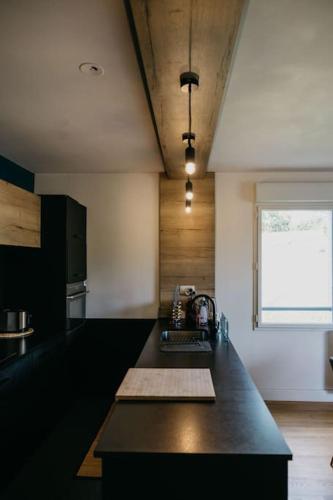 une cuisine avec un comptoir noir et une fenêtre dans l'établissement Appartement cosy avec wifi à 15 min de Rennes, à Crévin