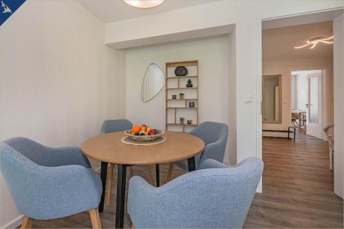 a dining room with a table and blue chairs at Ferienwohnung Lieblingseck in Bansin
