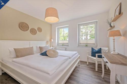 a bedroom with a large white bed and a desk at Ferienwohnung Lieblingseck in Bansin