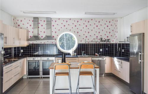 a kitchen with a sink and two bar stools at Cozy Apartment In Långaryd With Wifi in Långaryd