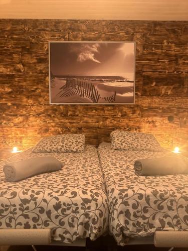 a bedroom with two beds and a picture on the wall at La Clé de Taulé in Taulé