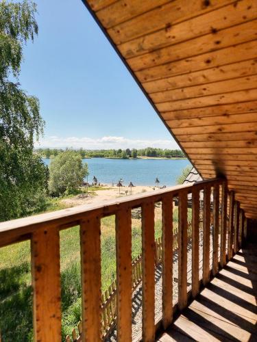 a wooden deck with a view of a beach at Osada Kryspinów in Cholerzyn