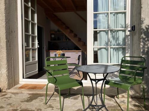 d'une terrasse avec une table, des chaises, une table et des chaises. dans l'établissement Maisonnette indépendante en lisière de forêt, à Recloses