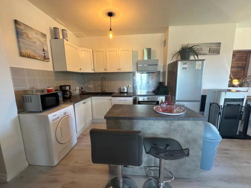 a kitchen with white cabinets and a counter with appliances at La Clé de Taulé in Taulé