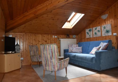 a living room with a blue couch and two chairs at Casa Barbóla in Sondalo