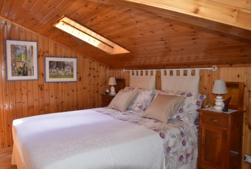 a bedroom with a white bed in a wooden ceiling at Casa Barbóla in Sondalo