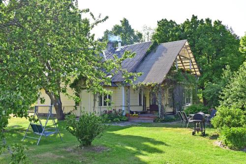 a white house with chairs in the yard at Jaunklāvi in Sīkrags