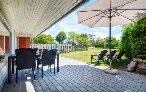 a patio with a table and an umbrella at Three-Bedroom Holiday Home In Bredebro in Ballum