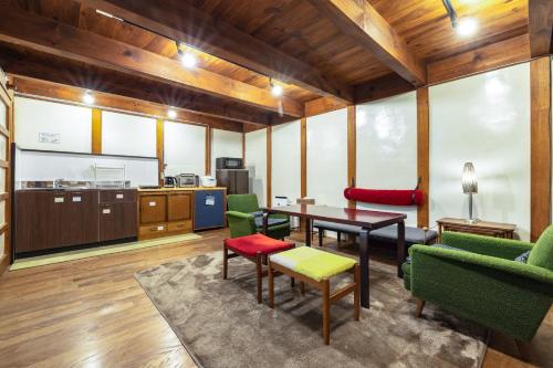 a living room with a table and green chairs at Popotel 2 KURA in Matsumoto