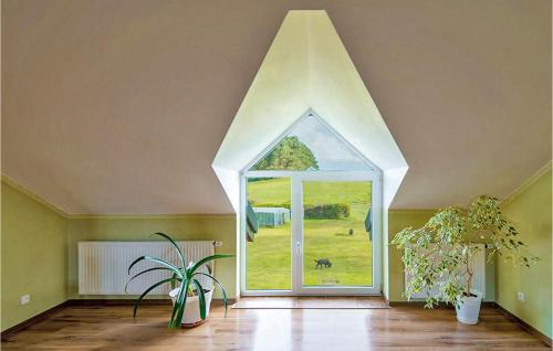 an attic room with an arched window and plants at Pod Lipa in Kożyczkowo