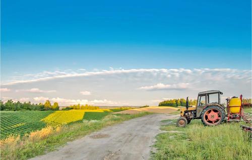 a tractor parked on a dirt road next to a field at Pod Lipa in Kożyczkowo