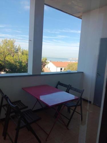 une table et des chaises dans une pièce avec une fenêtre dans l'établissement Face aux iles, à Marseille