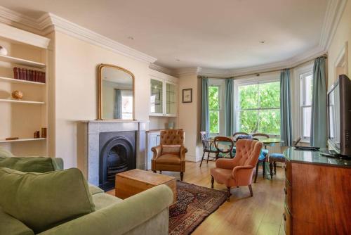 a living room with a fireplace and a dining room at 3BR Apt 5 min to BrightonStation in Brighton & Hove