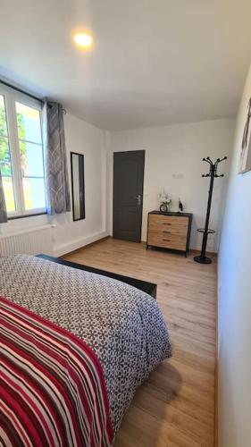 une chambre avec un lit, une commode et une fenêtre dans l'établissement Le Frêne Chantant, à Bazinval