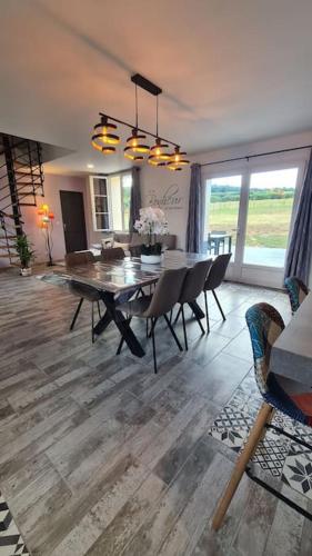 un salon avec une table et des chaises de salle à manger dans l'établissement Le Frêne Chantant, à Bazinval