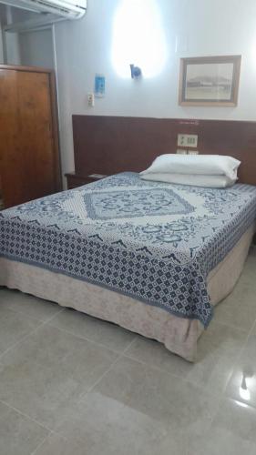 a bedroom with a bed with a blue quilt on it at St.Joseph Hotel in Luxor