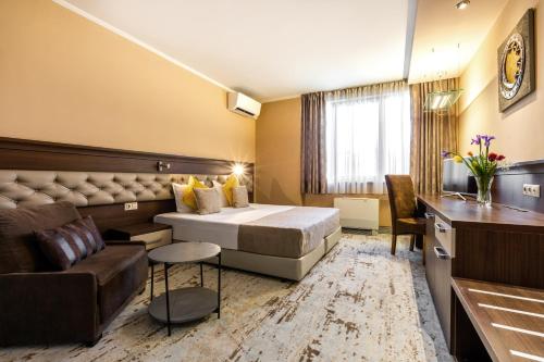 a hotel room with a bed and a couch at Business Hotel Plovdiv - Central Location in Plovdiv
