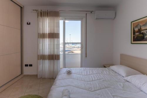 um quarto com uma cama e uma janela grande em Durres Port View Apartment em Durrës