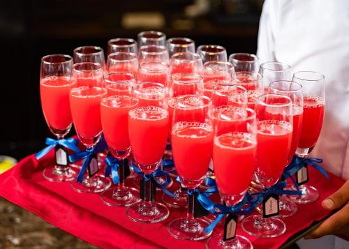 a tray of wine glasses filled with red drinks at Amanda Luxury Cruise in Ha Long