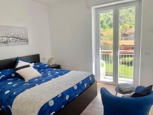 a bedroom with a blue bed and a sliding glass door at Lilly del Lago Maggiore in Castelveccana