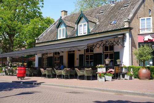 エッテン・ルールにあるHotel Het Witte Paardの通りにテーブルと椅子が並ぶ建物