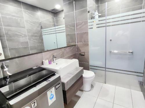 a bathroom with a sink and a toilet and a shower at Bell Suite Sepang Kota Warisan by DH in Sepang