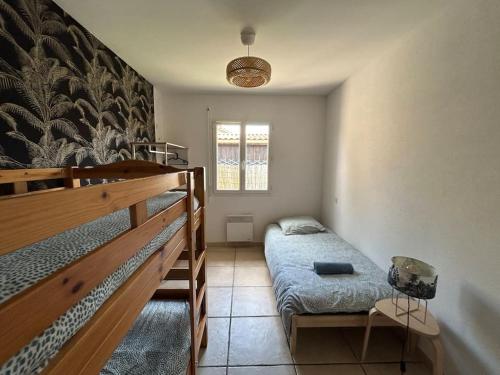 - une chambre avec des lits superposés à côté d'une fenêtre dans l'établissement Maison cosy proche du lac, à Lacanau