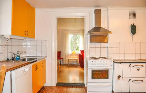 a kitchen with orange and white appliances and a living room at Amazing Home In Årjäng With Wifi in Årjäng