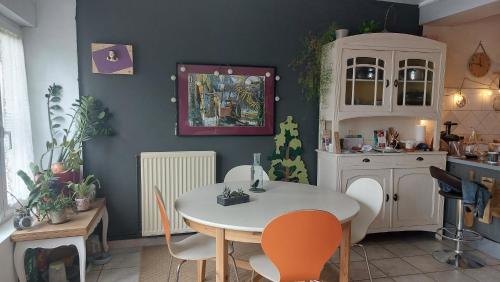 une cuisine avec une table et des chaises dans une pièce dans l'établissement 2 Chambres dans maison de caractère, à La Possonnière
