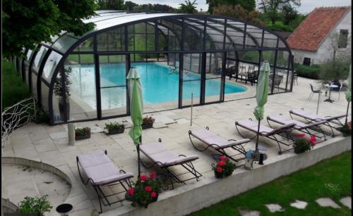 a group of chairs and a pool in a greenhouse at La Ferme de Couffy in Couffy