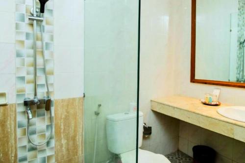 a bathroom with a toilet and a sink and a shower at Lintang 1 BR Superior Room JU46 in Mataram