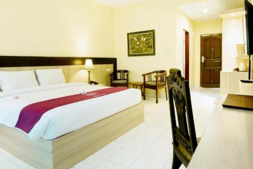a bedroom with a large bed and a table and chairs at Lintang 1 BR Superior Room JU46 in Mataram